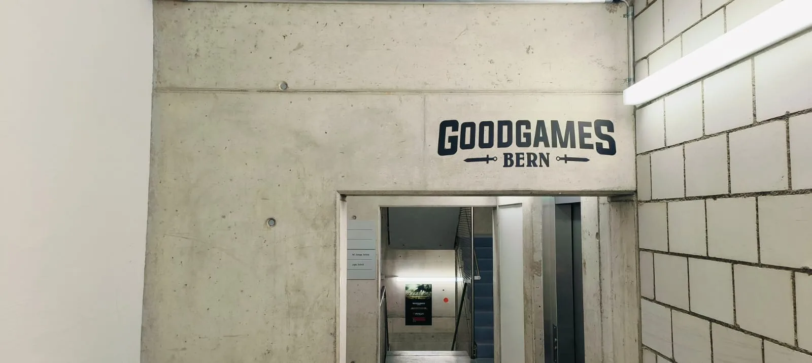 The GoodGames Bern logo painted on the concrete wall above the stairwell entrance