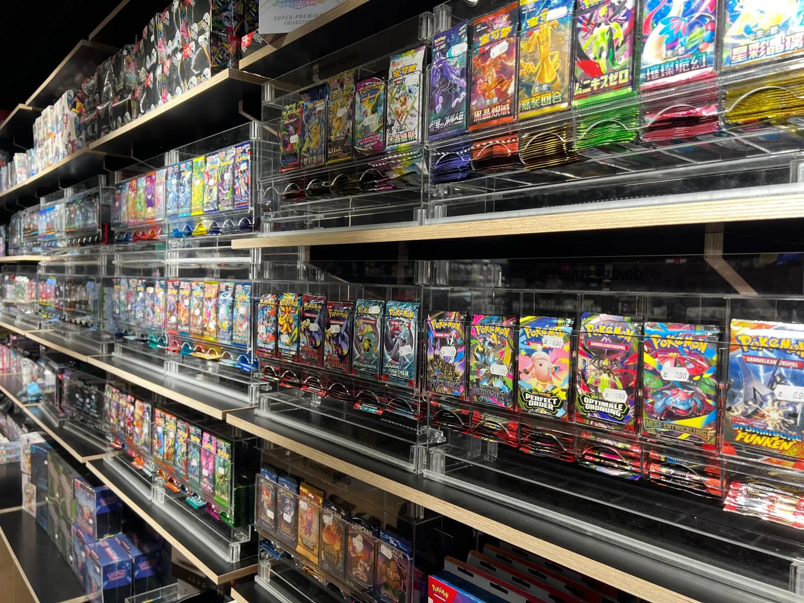 Acrylic-cased booster packs lined up across the shelf wall