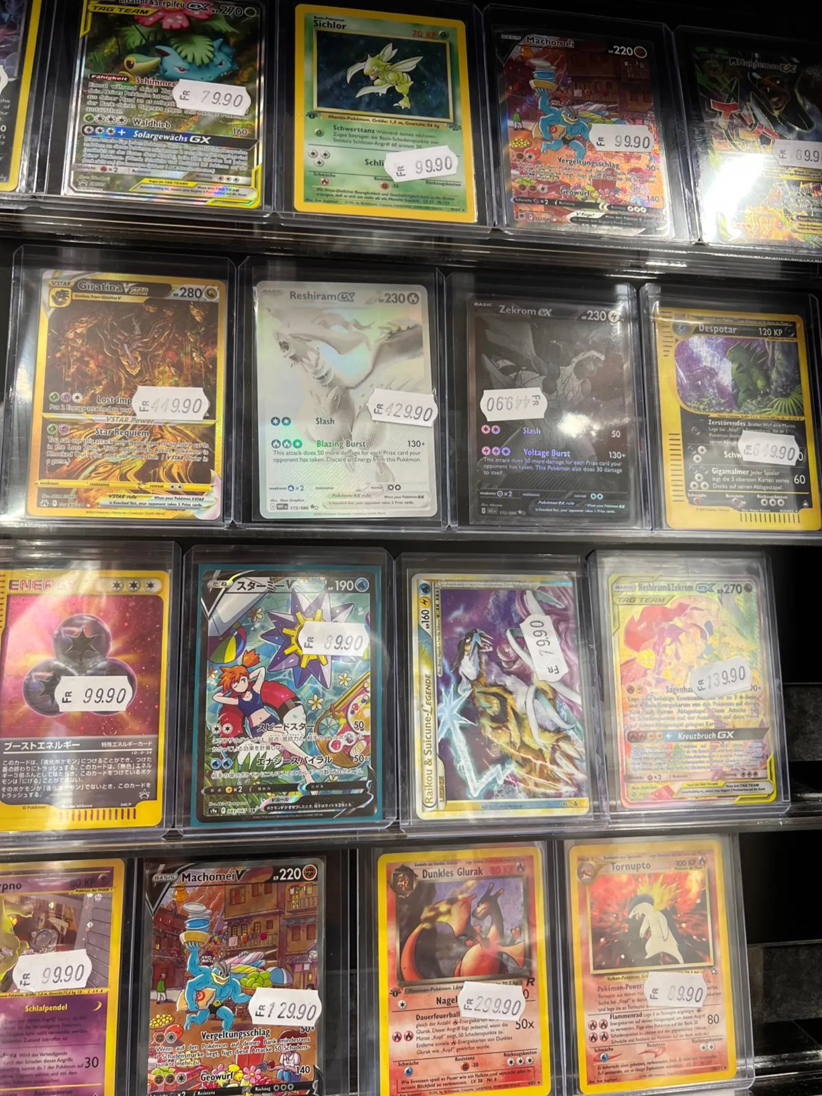 Close-up of graded and sleeved Pokémon cards on the singles wall