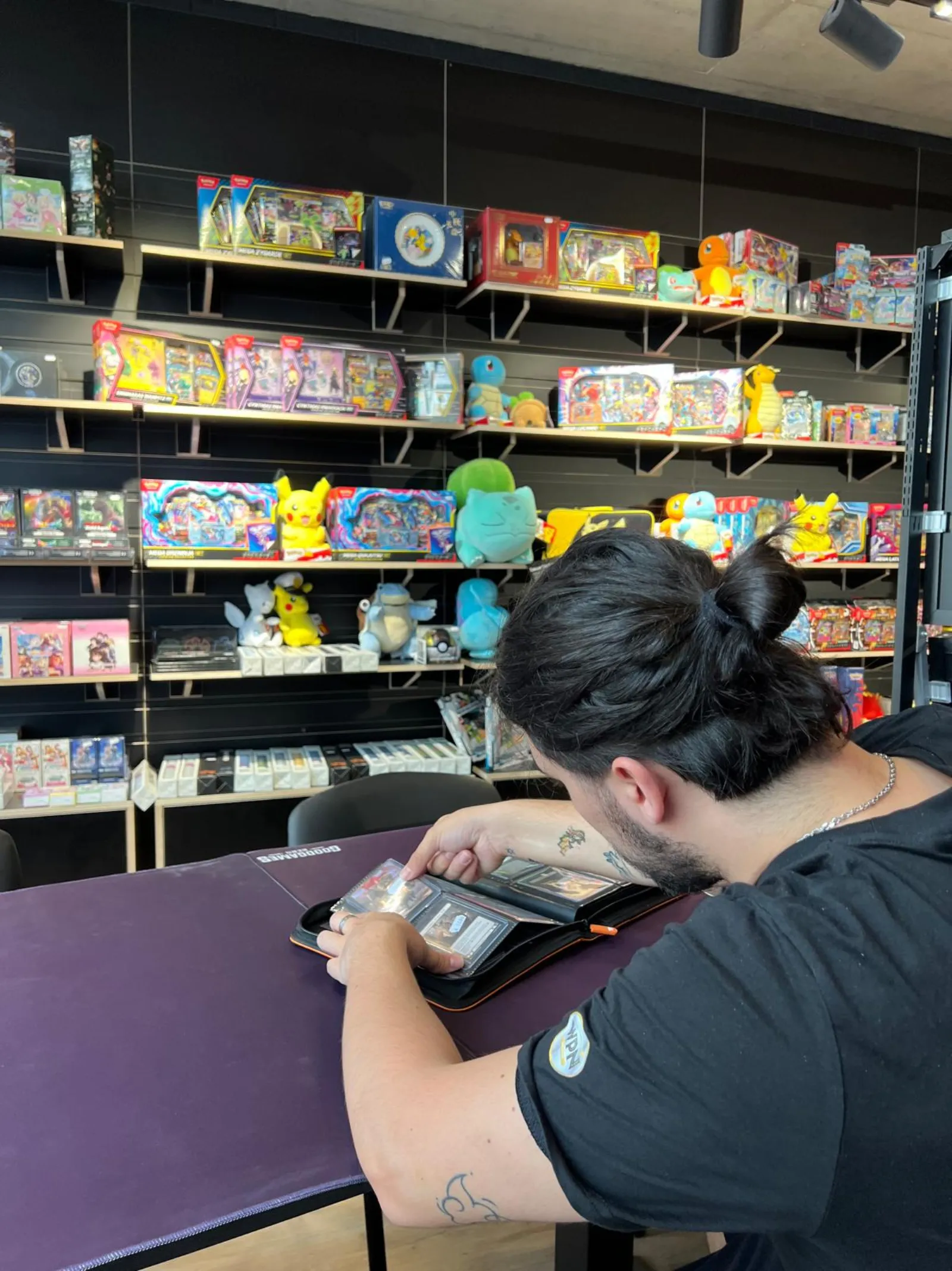 A player going through his card binder at one of the purple play tables
