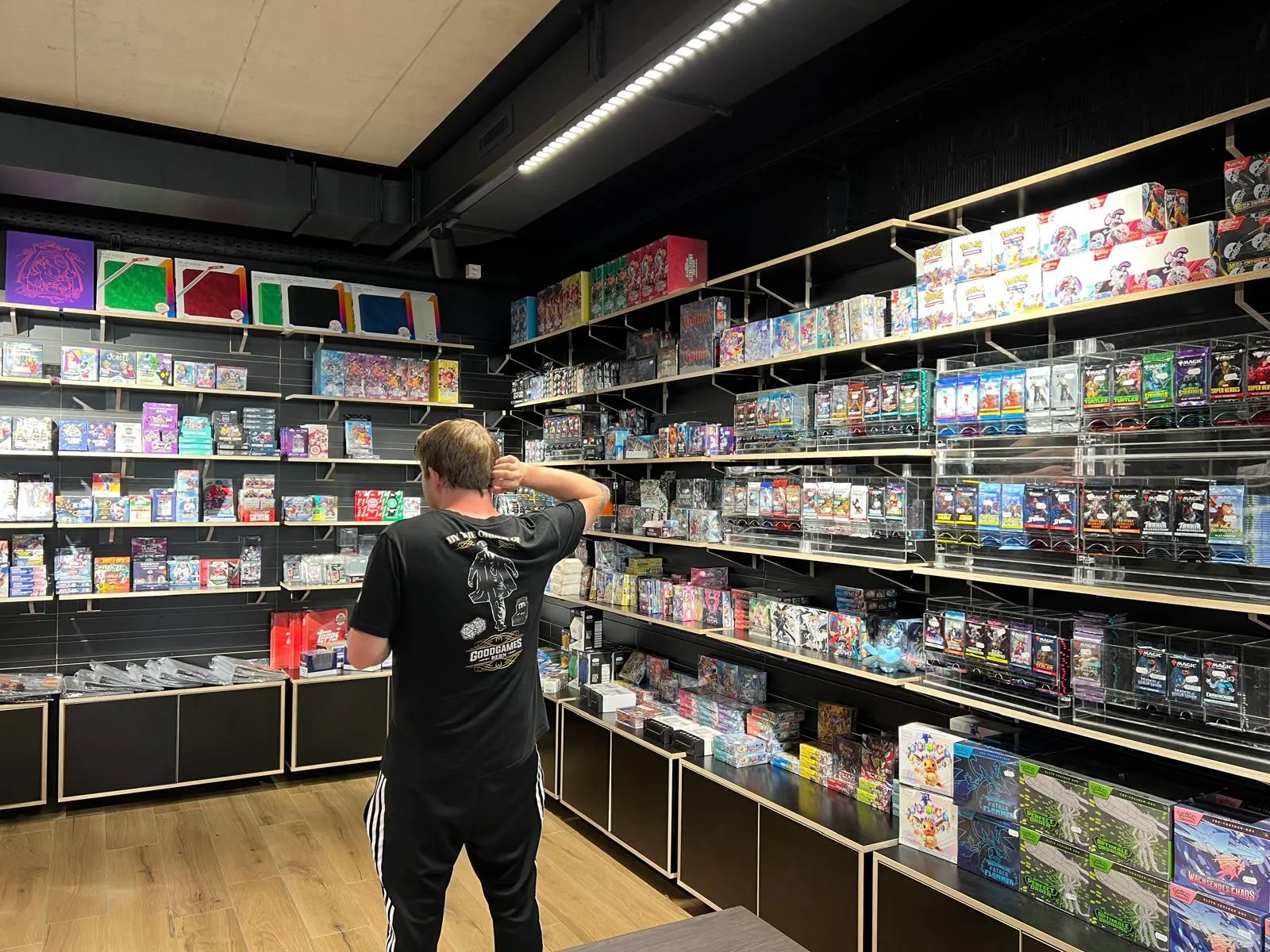 A staff member restocking booster packs on the shelf wall