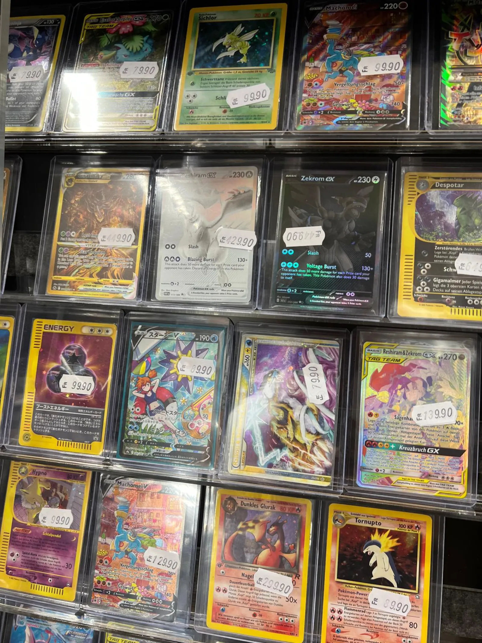 Premium Pokémon singles displayed behind glass with price tags